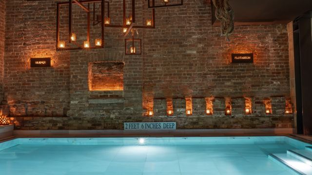 Candlelit thermal pool and brick walls at AIRE Ancient Baths, Tribeca